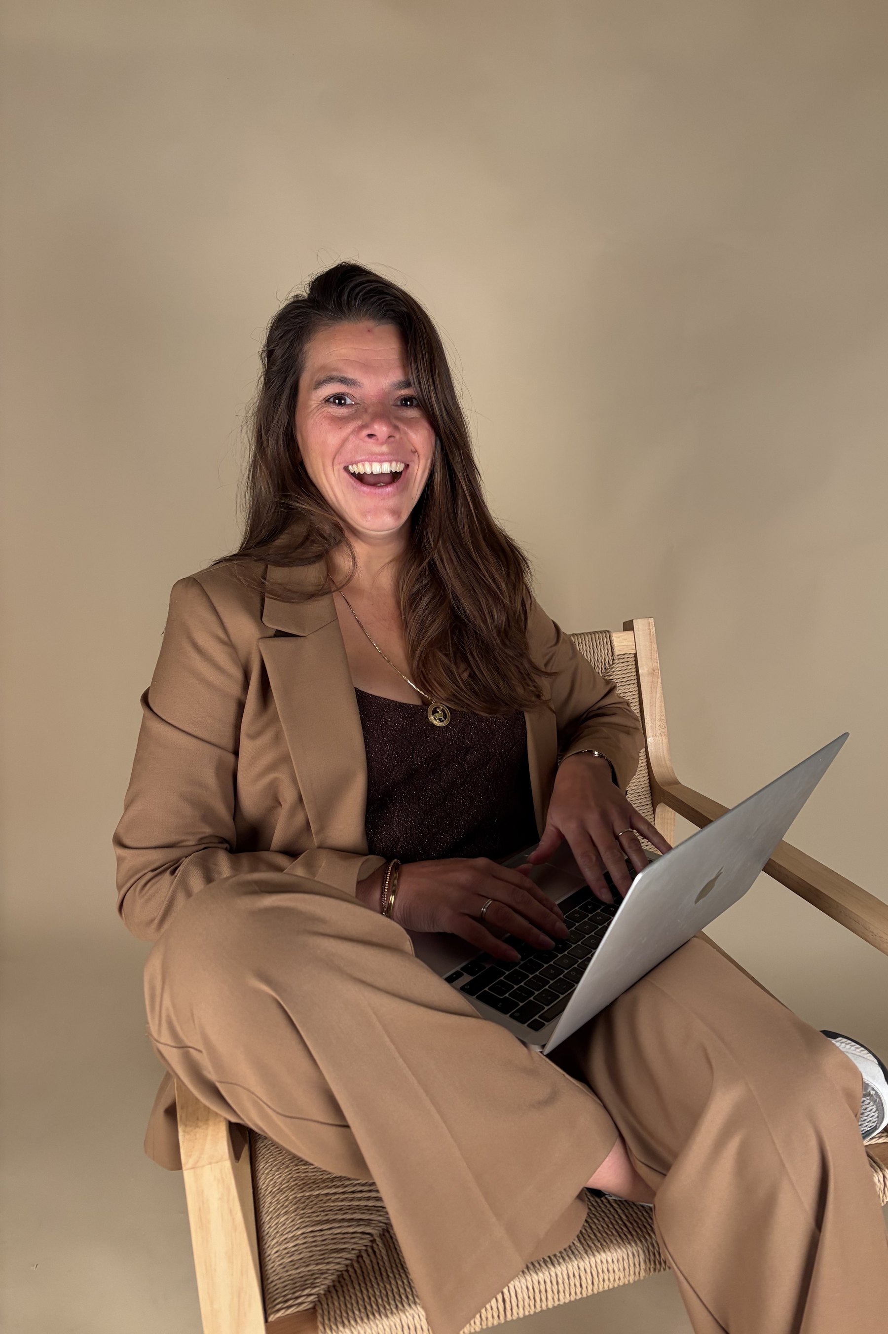 Denise Knapen lachend achter haar laptop