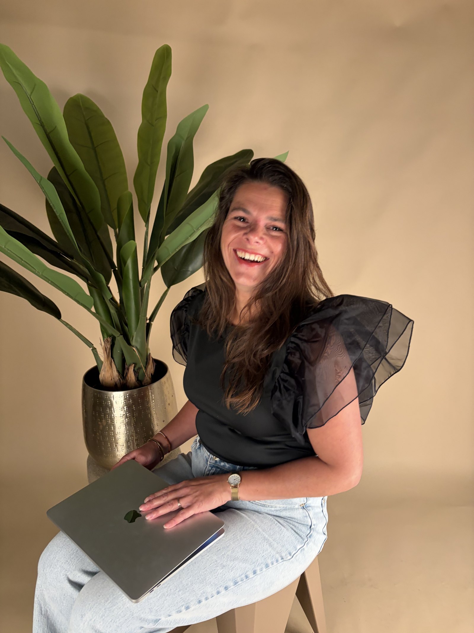 Denise Knapen lachend achter haar laptop